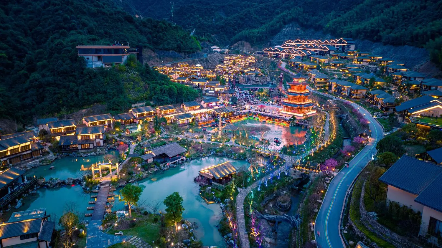 The enchanting Ge Xian Village illuminated at night, nestled among Jiangxi's lush mountains with traditional architecture and glowing lanterns.