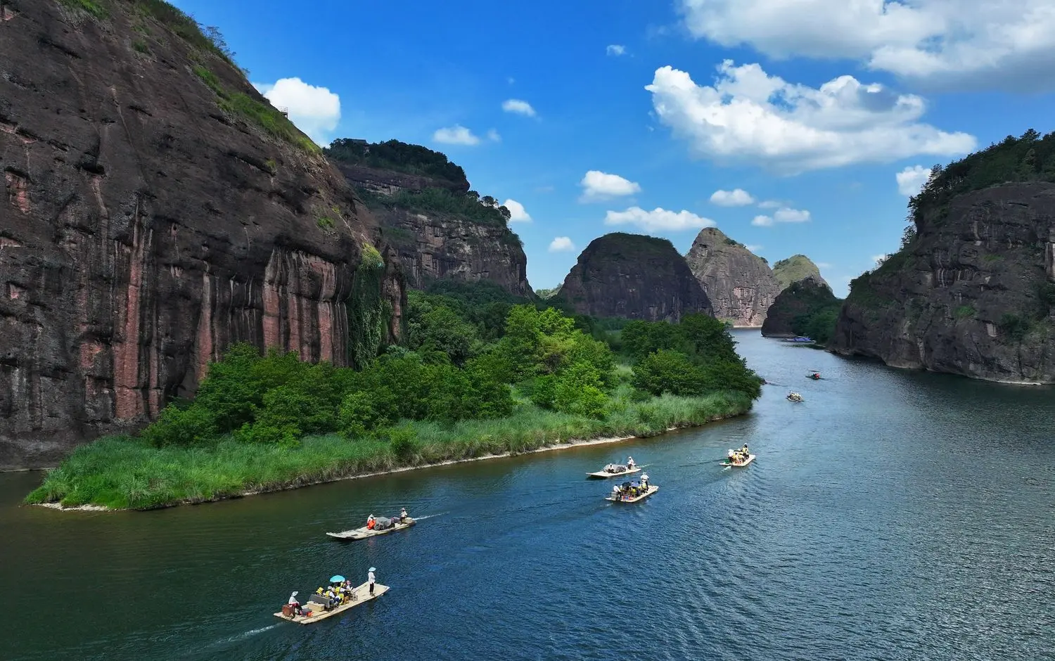 The breathtaking Longhu Mountain in Jiangxi, where bamboo rafts drift along the Lushui River between spectacular Danxia cliffs and lush forests.