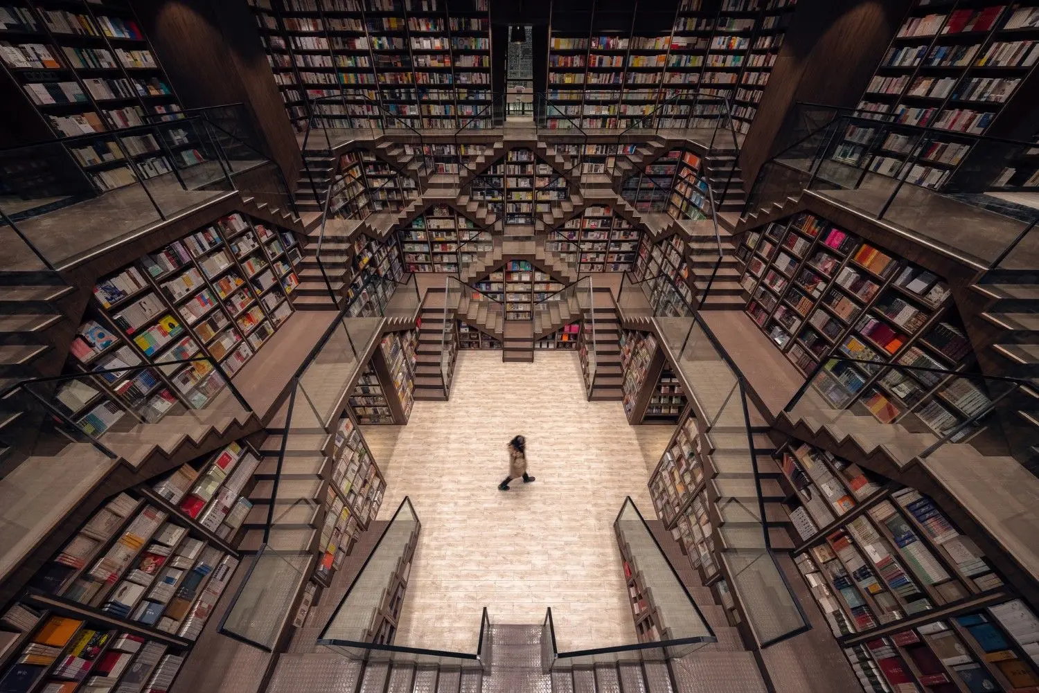 Overhead view of Zhongshuge Bookstore in China, featuring towering spiral bookshelves, mirrored architecture, and a breathtaking library interior recognized as one of the world's most beautiful bookstores.