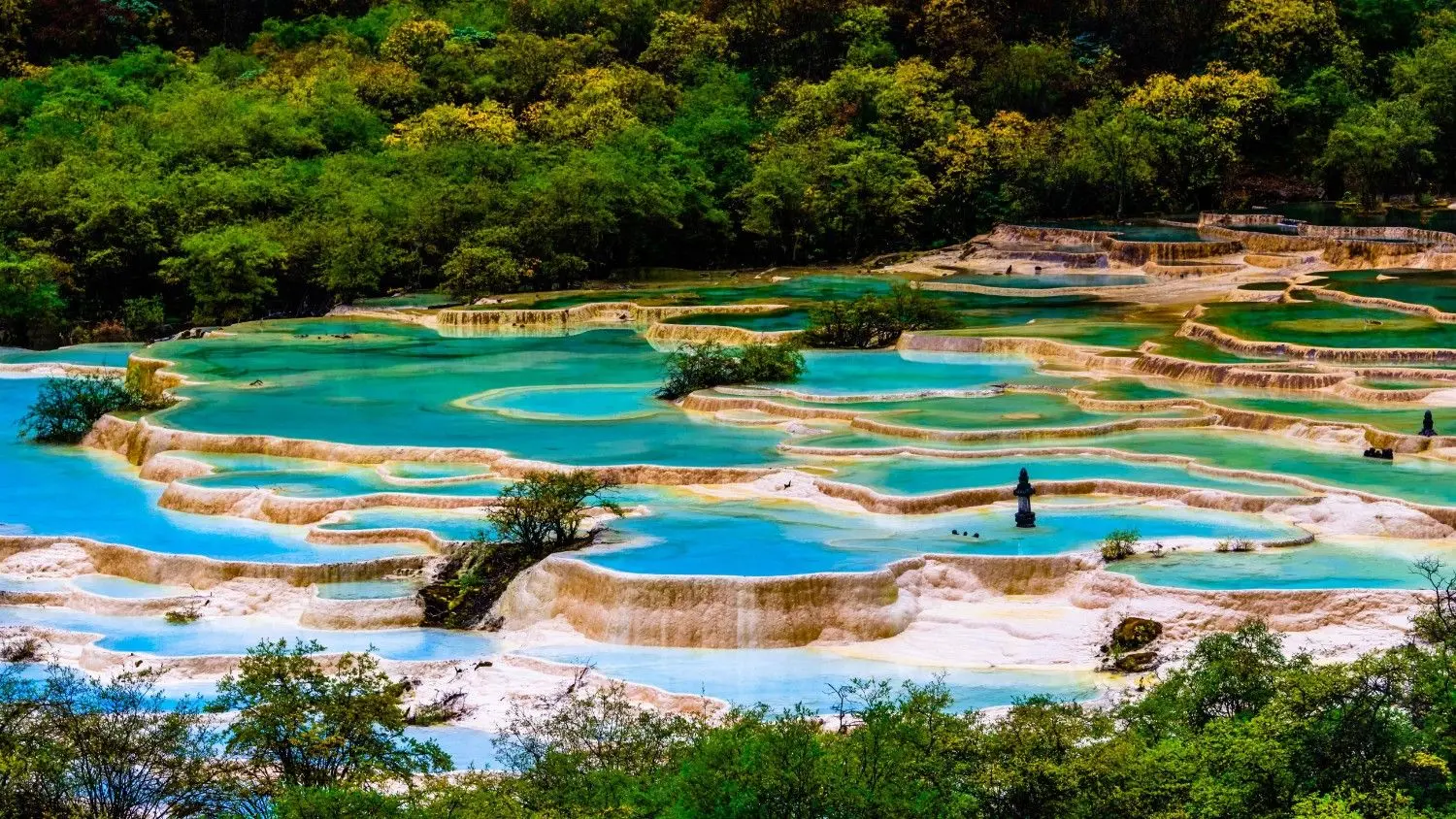 Huanglong Scenic Area in Sichuan, China, featuring colorful travertine pools, crystal-clear turquoise waters, limestone terraces, and breathtaking mountain scenery at a UNESCO World Heritage Site.