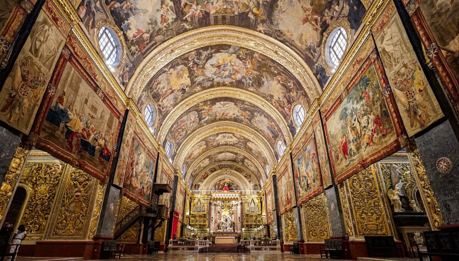 St. John’s Co-Cathedral interior in Valletta, Malta with ornate Baroque artwork and frescoed ceilings