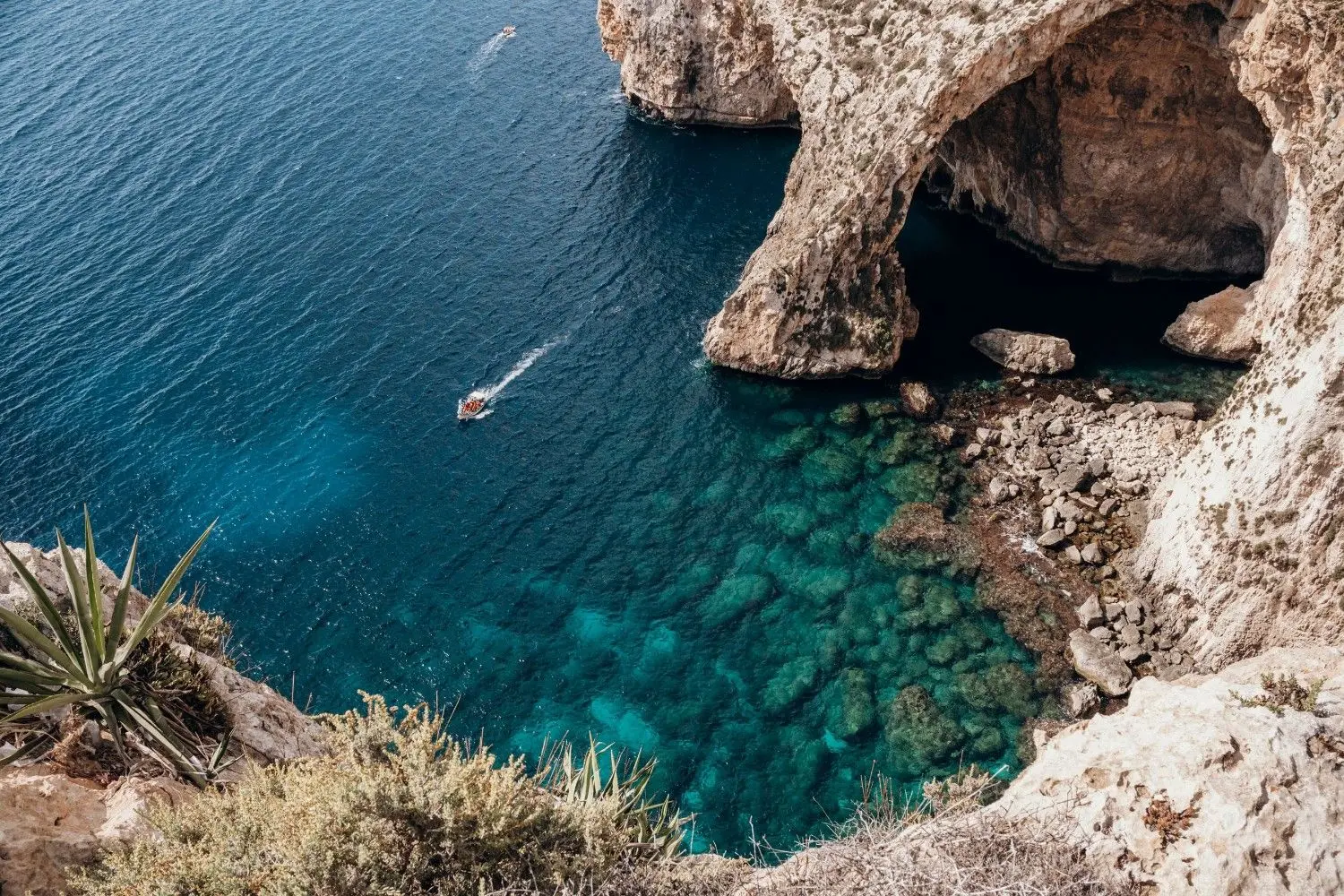 The breathtaking Blue Grotto in Malta, featuring dramatic limestone sea caves, crystal-clear turquoise Mediterranean waters, and scenic boat tours along the southern coastline.