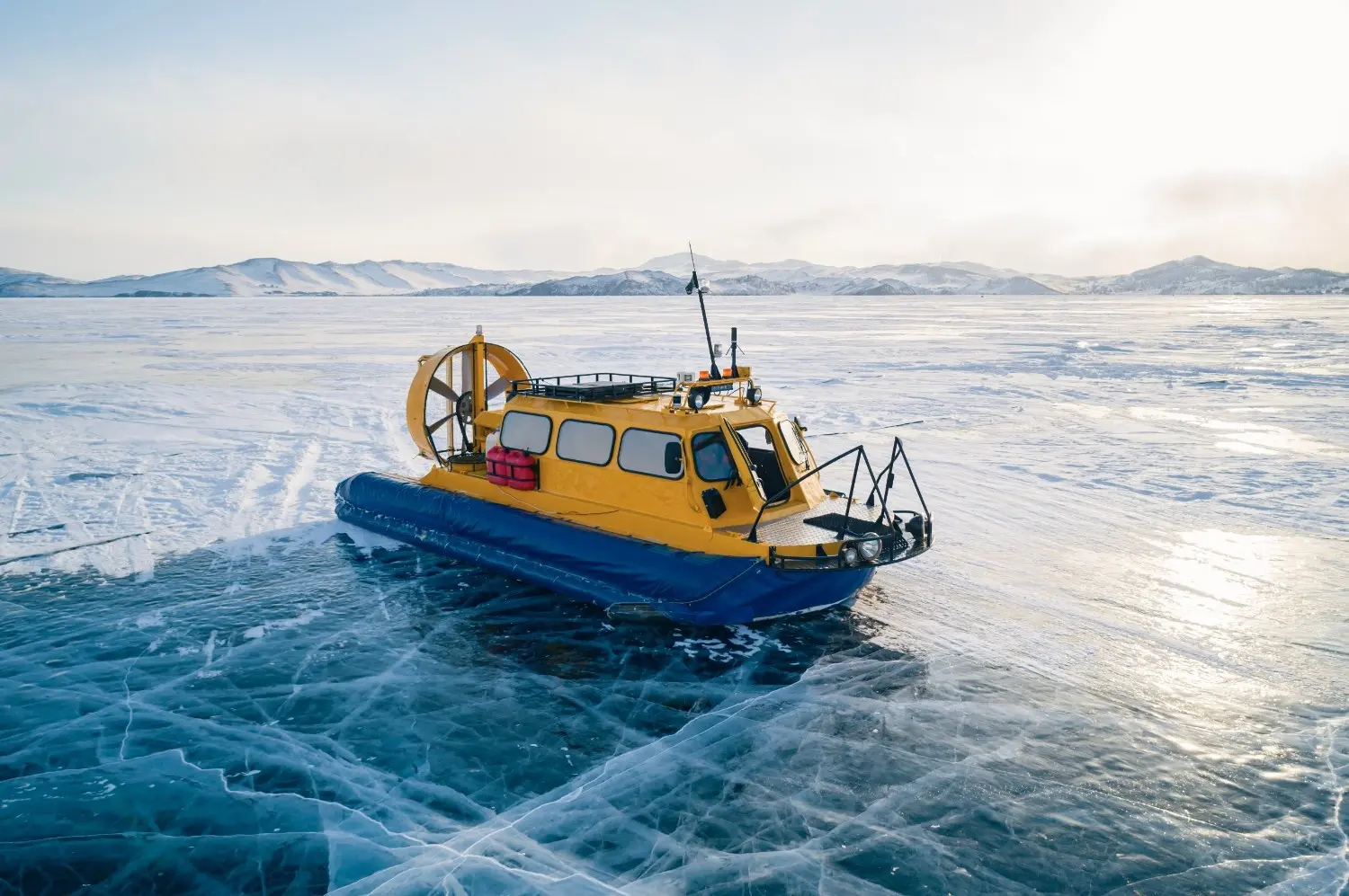 Ice boat on the frozen surface of Lake Baikal, Russia, showcasing crystal-clear blue ice, breathtaking winter scenery, and one of Siberia's most unforgettable adventure travel experiences.