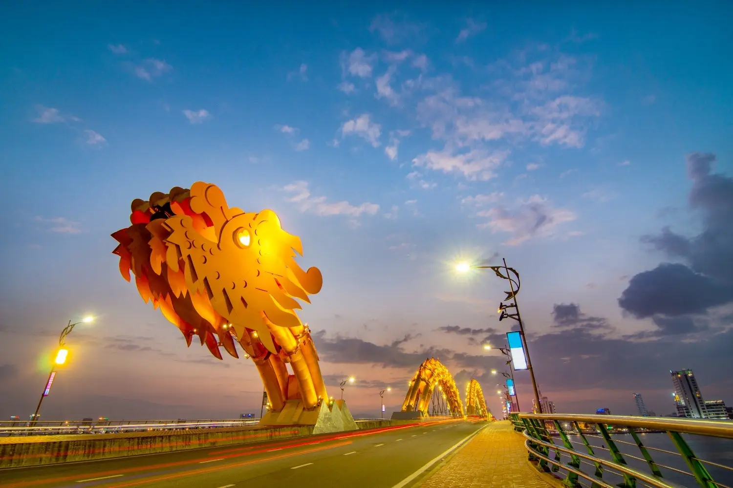 Dragon Bridge (Cầu Rồng) in Da Nang, Vietnam, illuminated at dusk with its iconic golden dragon sculpture, showcasing one of Vietnam's most famous modern landmarks.