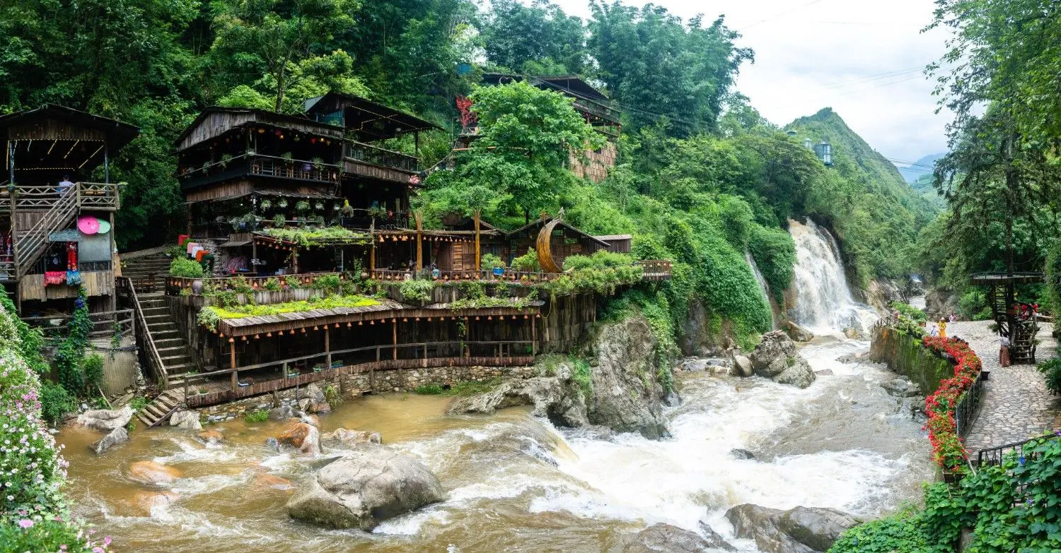 Cat Cat Village in Sapa, Vietnam, featuring traditional Hmong wooden houses, cascading waterfalls, mountain streams, and lush green landscapes, offering an authentic glimpse into the culture of Northern Vietnam's ethnic communities.