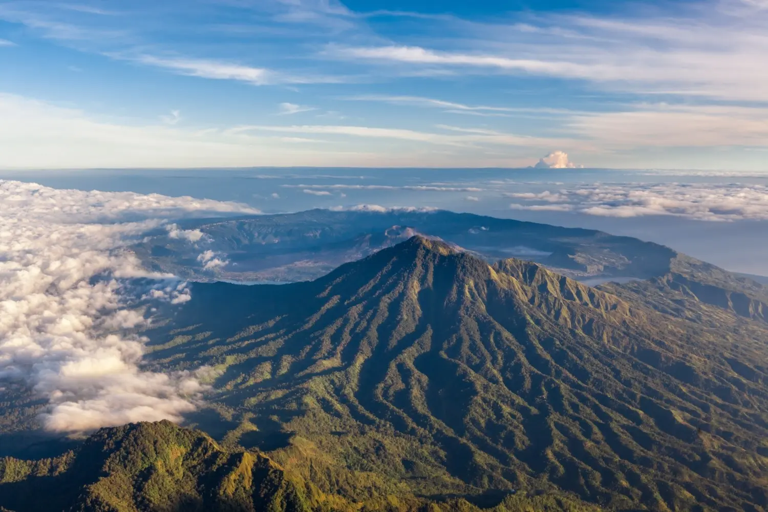 Mount Batur in Kintamani, Bali, Indonesia, featuring a majestic volcanic peak rising above the clouds, dramatic mountain ridges, and breathtaking sunrise views. One of Bali's most iconic active volcanoes and a popular destination for hiking and nature photography.