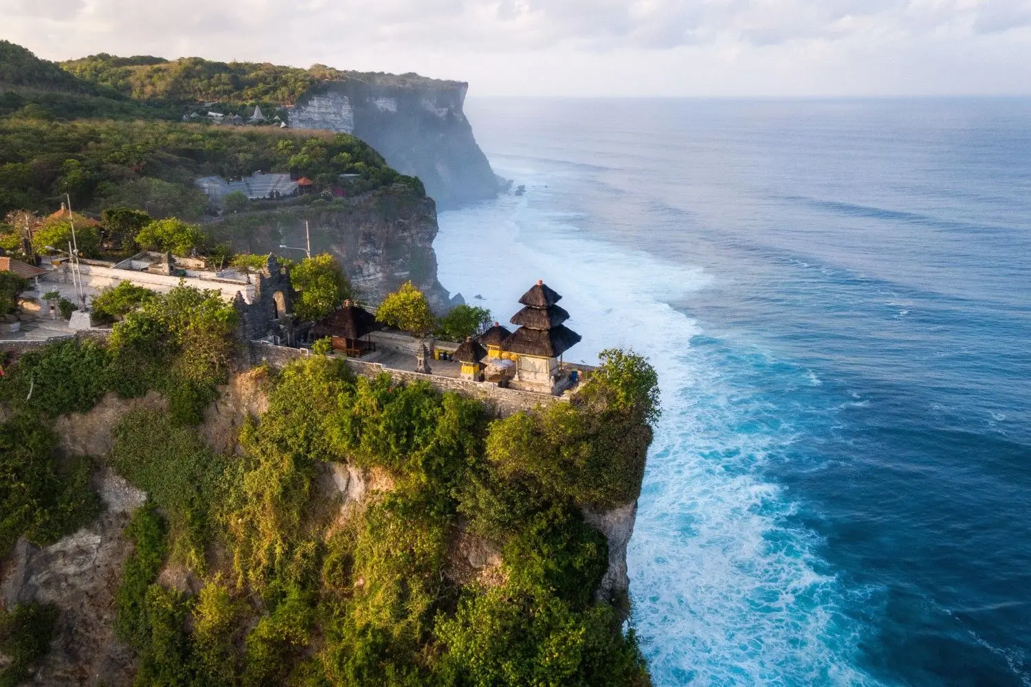 Uluwatu Temple (Pura Luhur Uluwatu) in Bali, Indonesia, featuring a majestic Hindu sea temple perched on dramatic limestone cliffs overlooking the Indian Ocean. One of Bali's most iconic cultural landmarks, famous for its breathtaking sunset views and traditional Kecak dance performances.