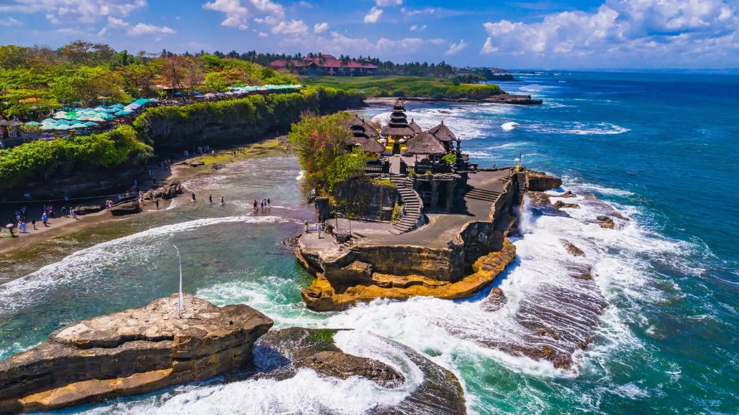 Tanah Lot Temple (Pura Tanah Lot) in Bali, Indonesia, featuring an iconic Hindu sea temple perched on a dramatic offshore rock formation, surrounded by crashing Indian Ocean waves. One of Bali's most famous cultural landmarks, renowned for its spectacular sunsets, coastal scenery, and spiritual significance.