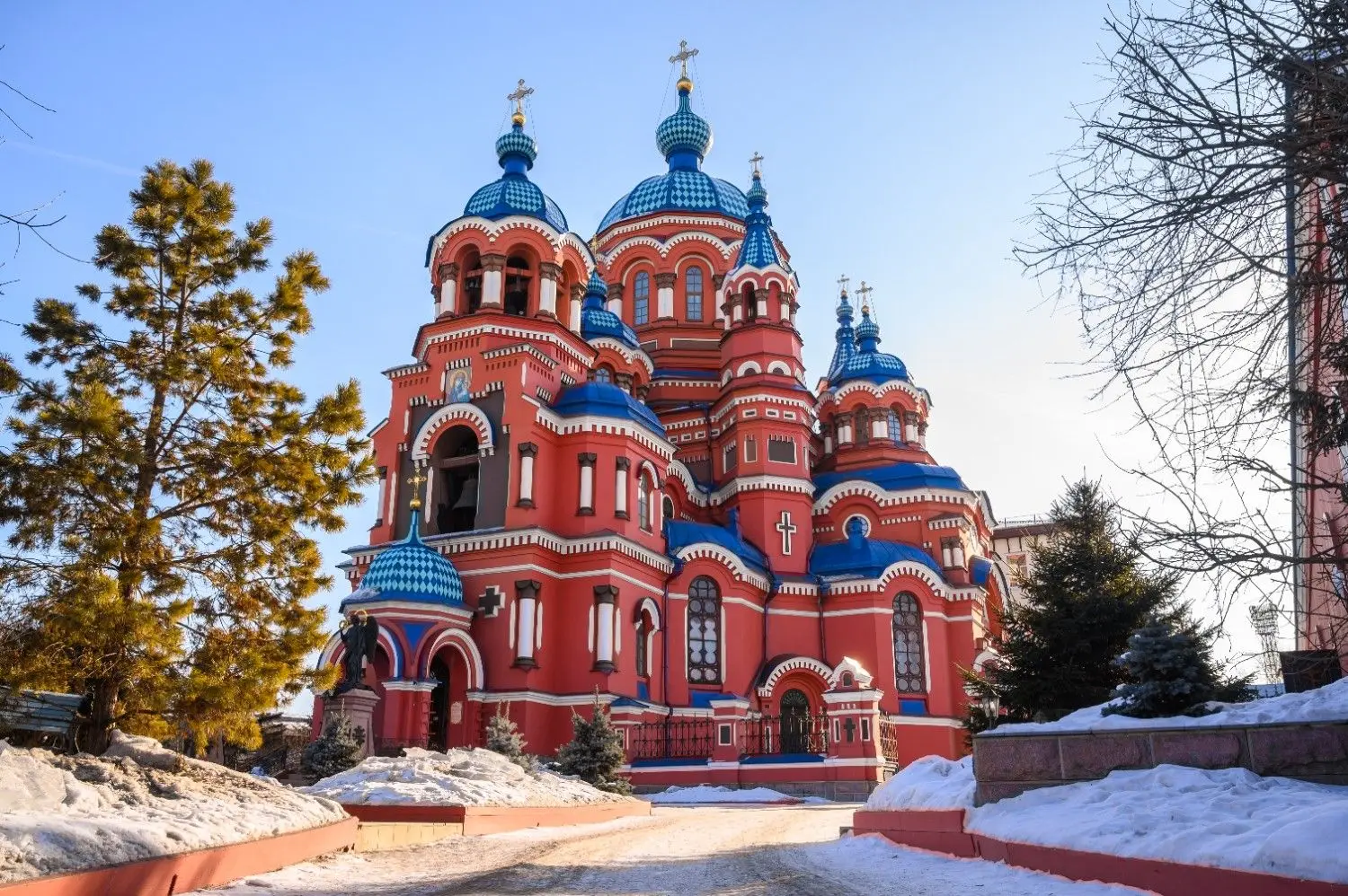 Cathedral of the Kazan Icon of the Mother of God in Irkutsk, Russia, featuring striking red-brick architecture, vibrant blue onion domes, and ornate Russian Orthodox design. One of Siberia's most beautiful churches, renowned for its rich history, religious significance, and stunning architectural details.