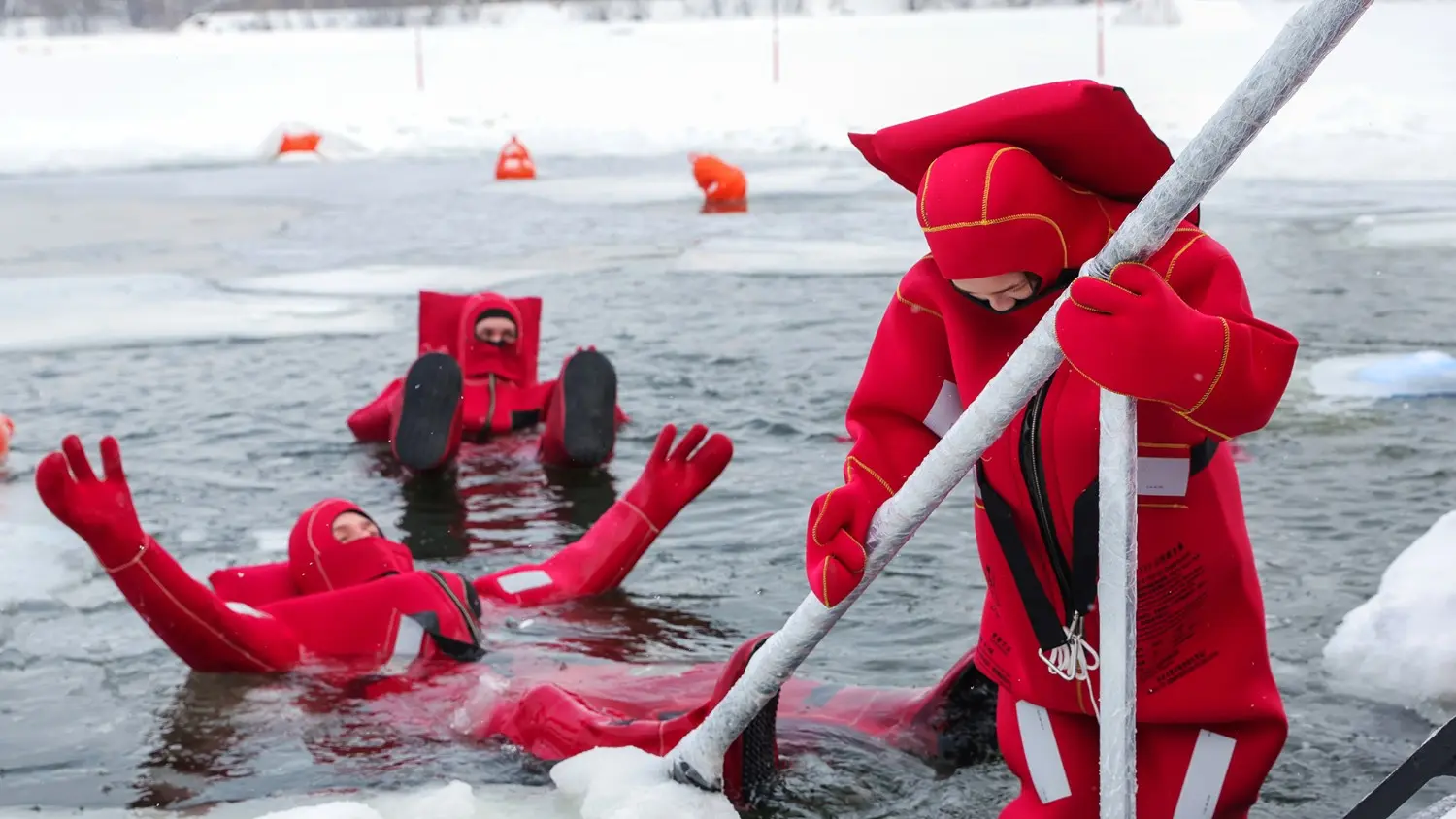 Arctic ice floating experience in Murmansk, Russia, featuring travelers wearing insulated survival suits while floating safely in icy waters surrounded by snow and ice. A unique winter adventure in the Russian Arctic.